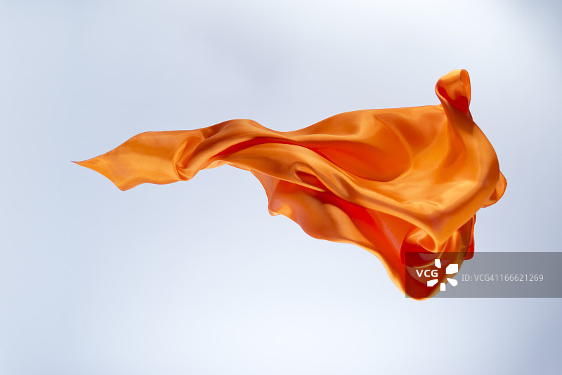 明亮背景上的漂浮橙色丝绸图片素材