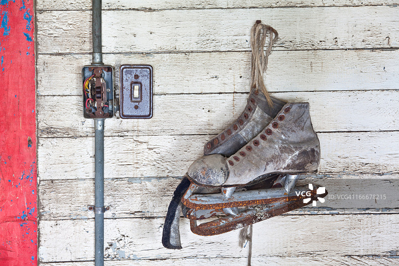 挂在墙上的锈迹旧冰鞋图片素材