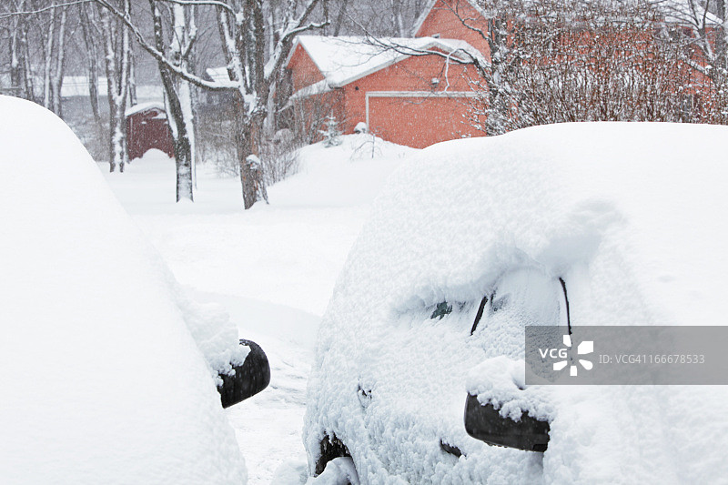 暴风雪过后，车道上覆盖着的汽车图片素材