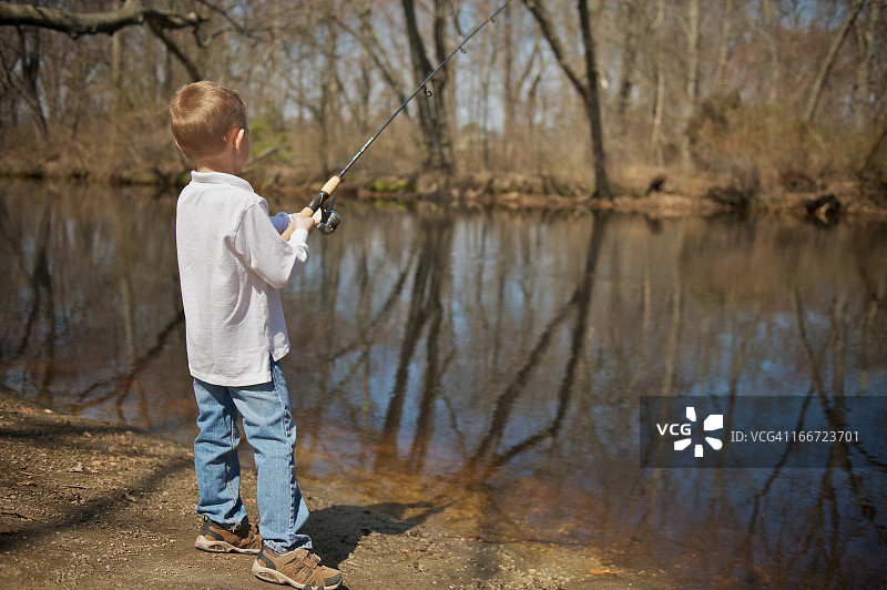 在小溪里钓鱼的小男孩图片素材