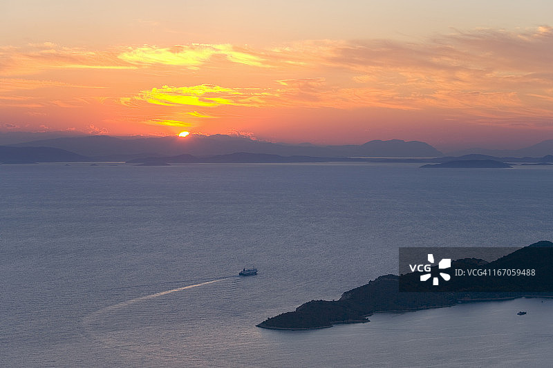 黎明时离开希腊伊萨卡岛瓦蒂港口的渡轮图片素材