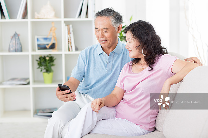 两位年长的亚洲人在看手机图片素材
