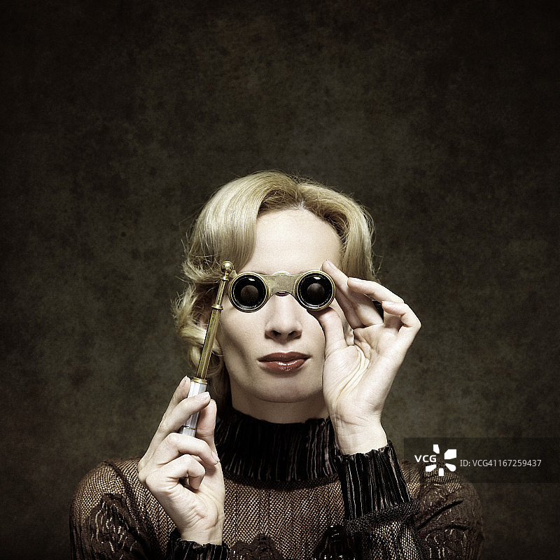 拿着歌剧眼镜的复古女人图片素材