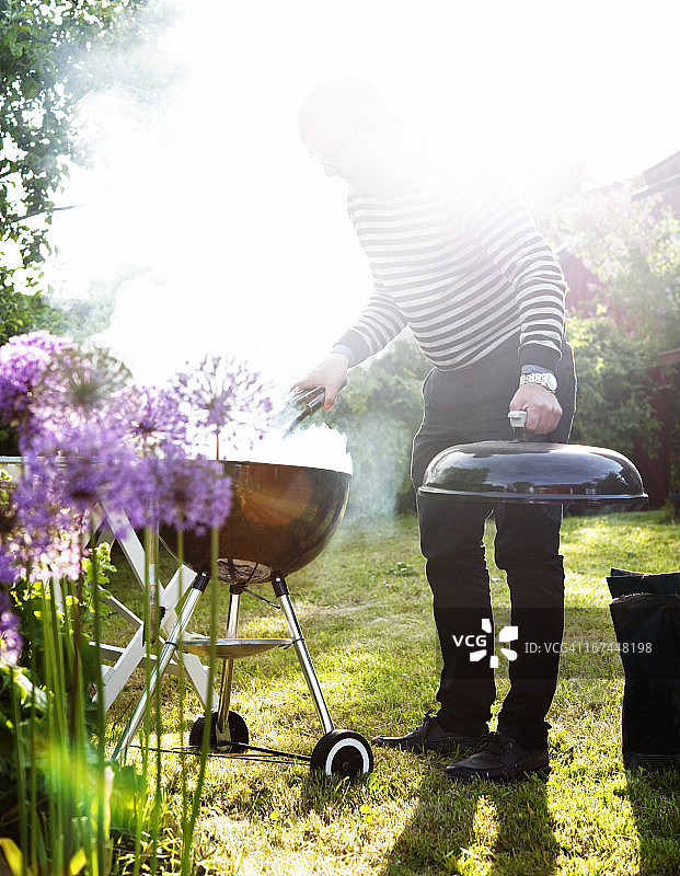 男子在花园烧烤图片素材