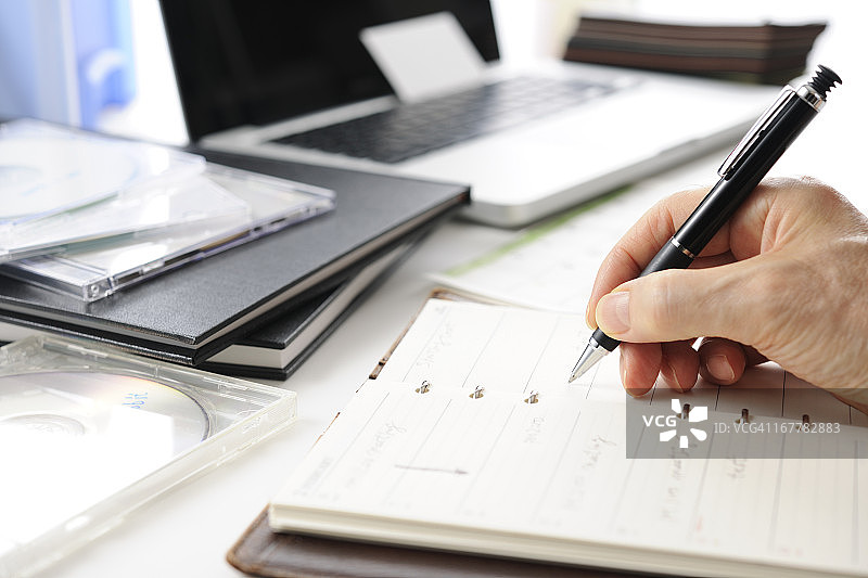 忙碌的商人正在写日程安排图片素材
