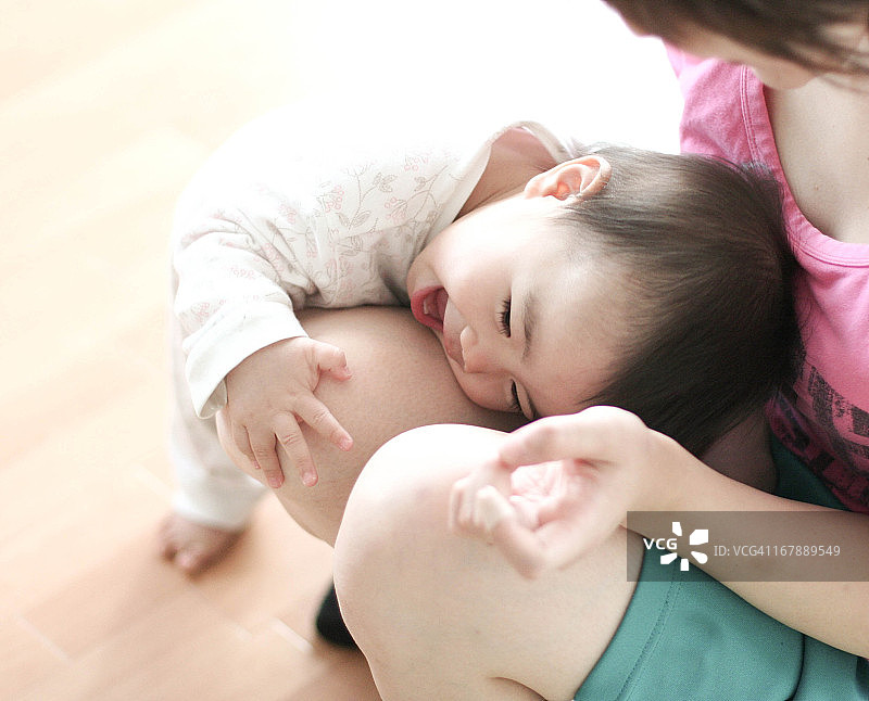 宝宝在妈妈的腿上玩耍图片素材