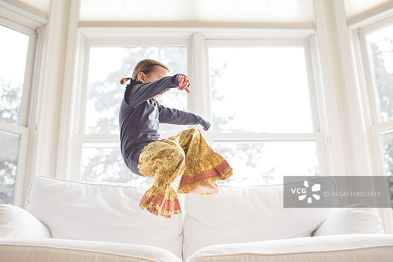 女孩在沙发上跳跃图片素材