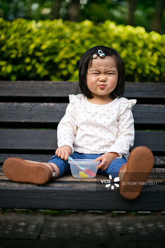 幼儿在长椅上吃零食图片素材