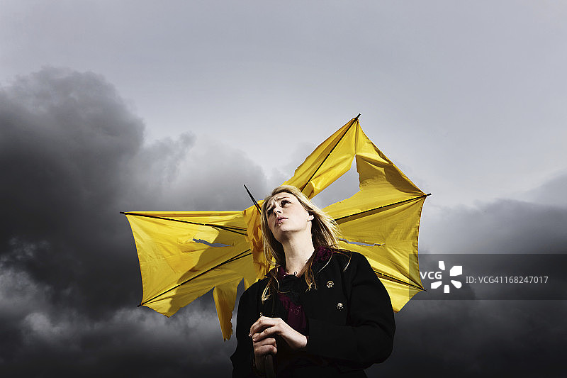 给我庇护！雷雨中拿着坏伞的悲伤金发女人图片素材