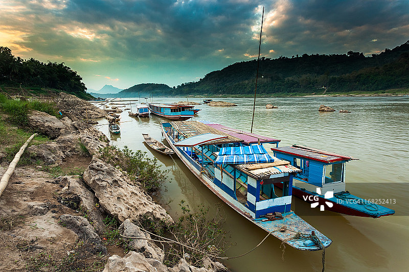 湄公河日落时的蓝色船只图片素材