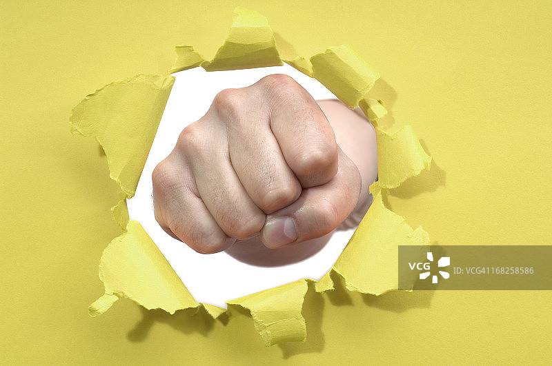 拳头冲破纸张的破洞图片素材