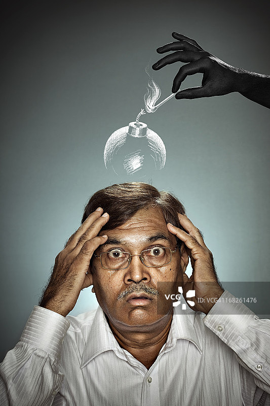 震惊的中年男人头上拿着点燃的炸弹图片素材