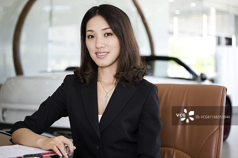 汽车销售女文员在办公桌前处理文件图片素材