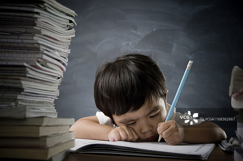 抱着一摞书的小男孩图片素材