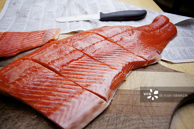 砧板上的野生捕获的三文鱼生鱼片图片素材