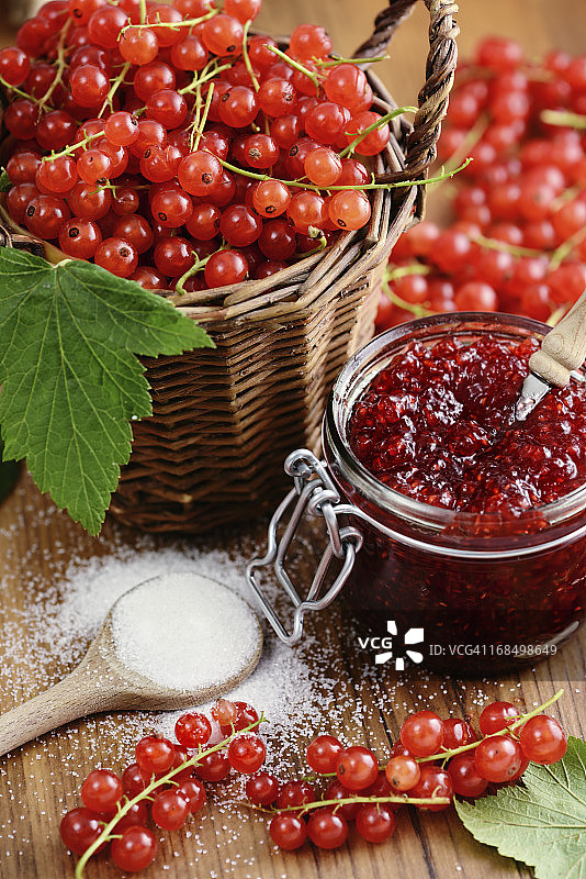 一篮红醋栗和带勺子的果酱罐图片素材