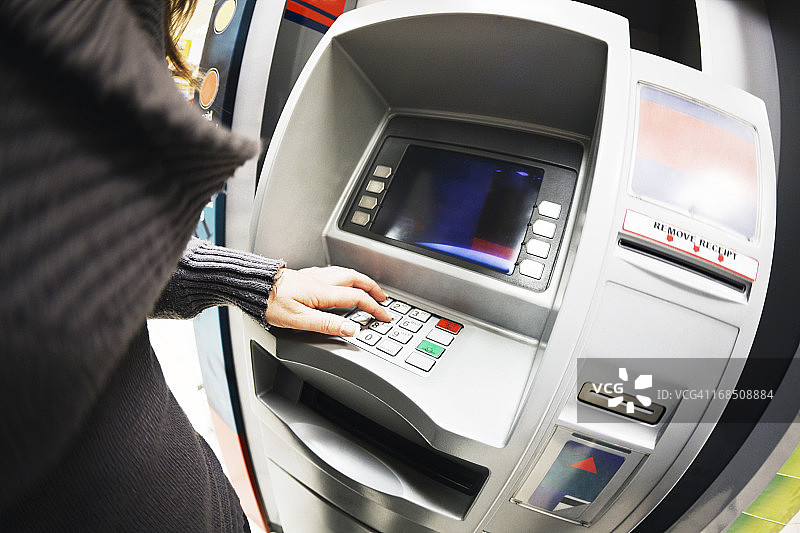 女人在银行ATM机上输入详细信息图片素材