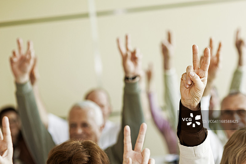 在研讨会上举手的年长学生图片素材