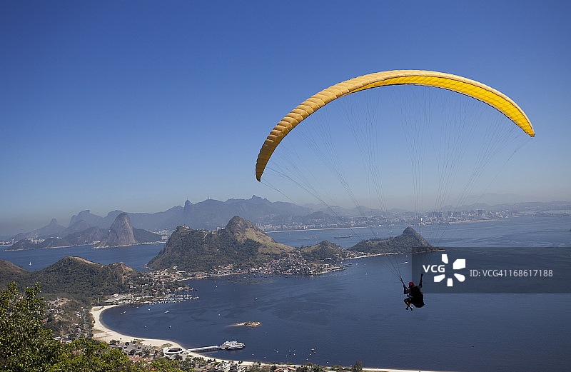 在里约热内卢平静的蓝色海上玩滑翔伞的人图片素材