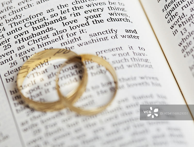 放置在《英王詹姆斯圣经》上的金色结婚戒指图片素材
