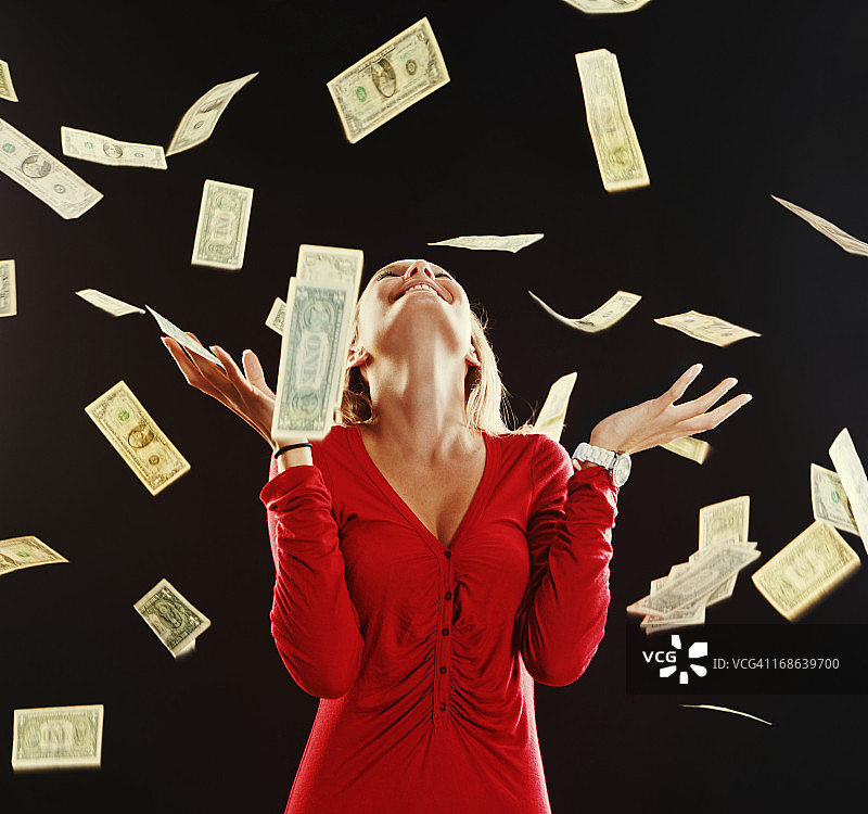 金发美女在美元雨中欣喜微笑图片素材