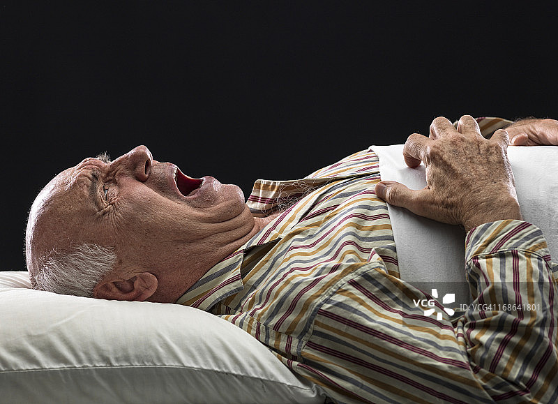 一位卧病在床、倍受折磨的老年男人图片素材