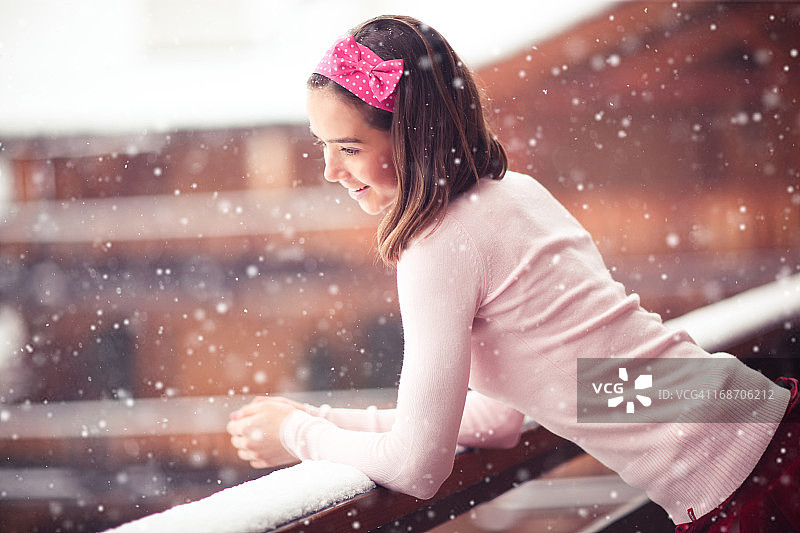倚靠在阳台上看雪的女孩图片素材