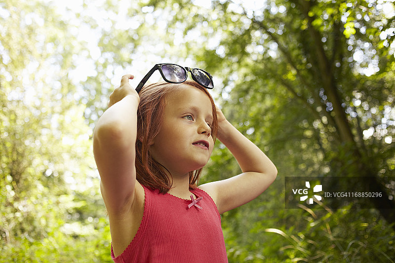 玩太阳镜的微笑女孩图片素材