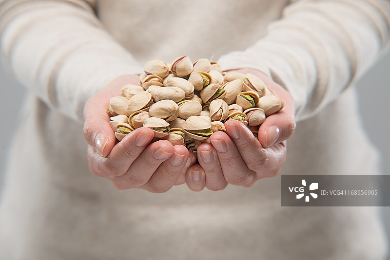 女人拿着开心果图片素材