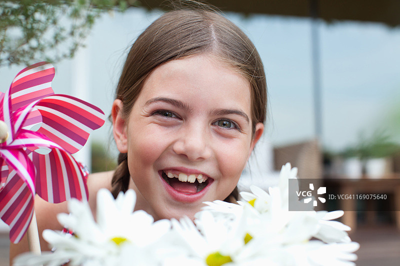 在户外拿着风车的微笑女孩图片素材