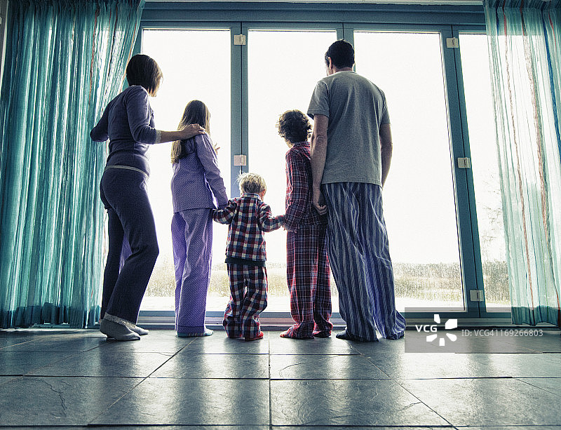 一家人穿着睡衣在看窗外图片素材