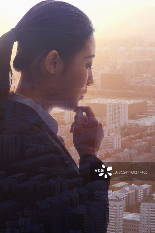 沉思的年轻女商人侧面轮廓，北京城市景观的双重曝光图片素材