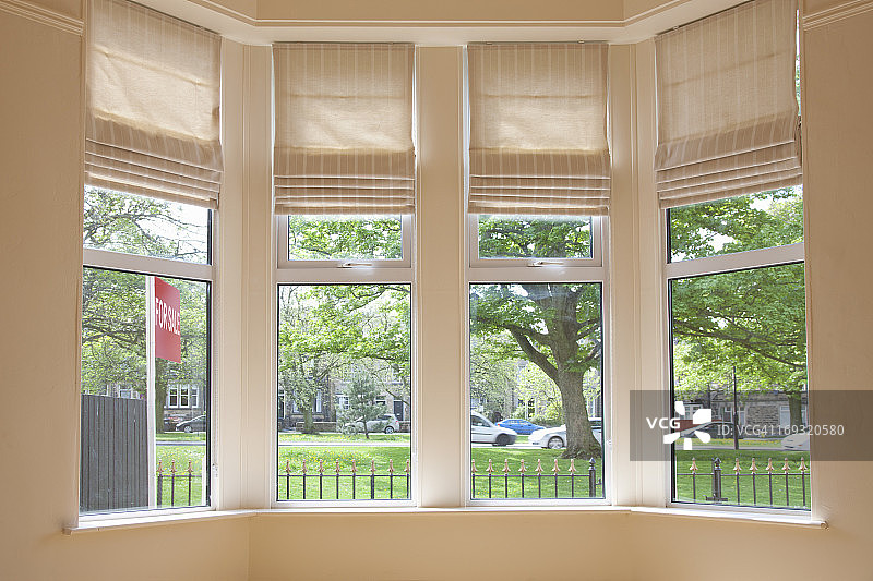 透过房屋窗户看到的出售标志牌图片素材