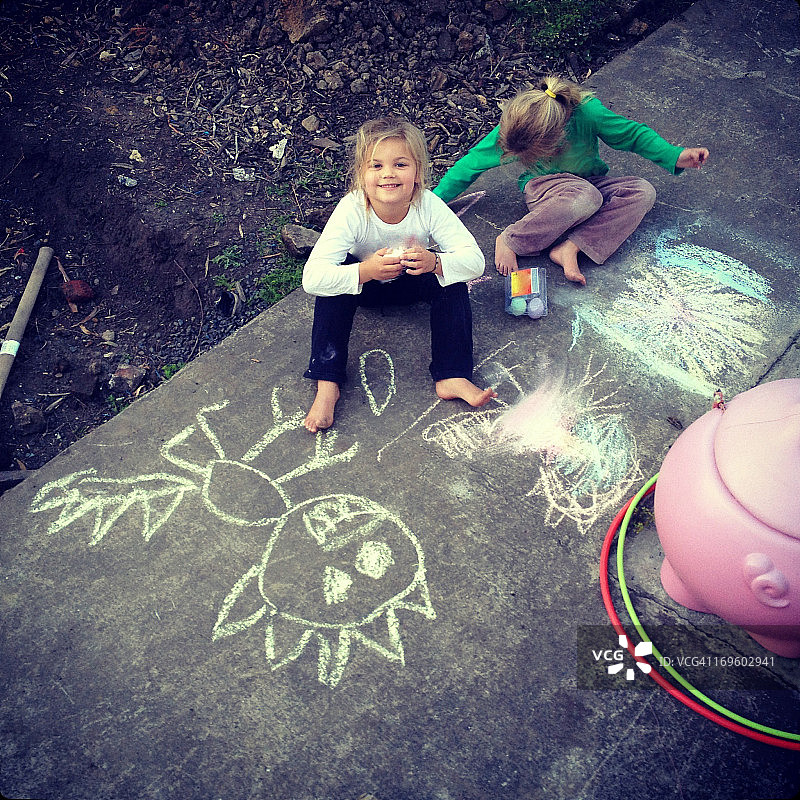 孩子们在水泥地上用粉笔画画图片素材