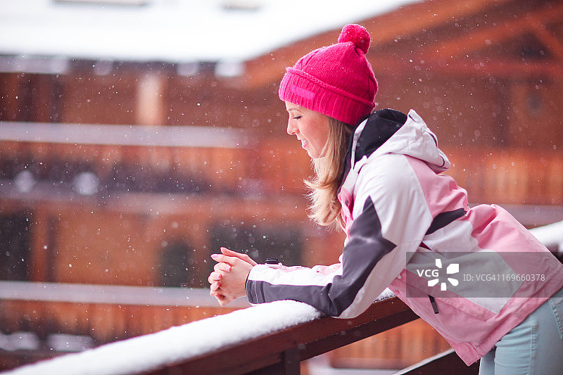 女孩在小木屋里观赏雪景图片素材