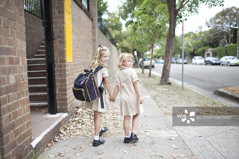 重返校园：两个年轻女孩走在上学路上图片素材