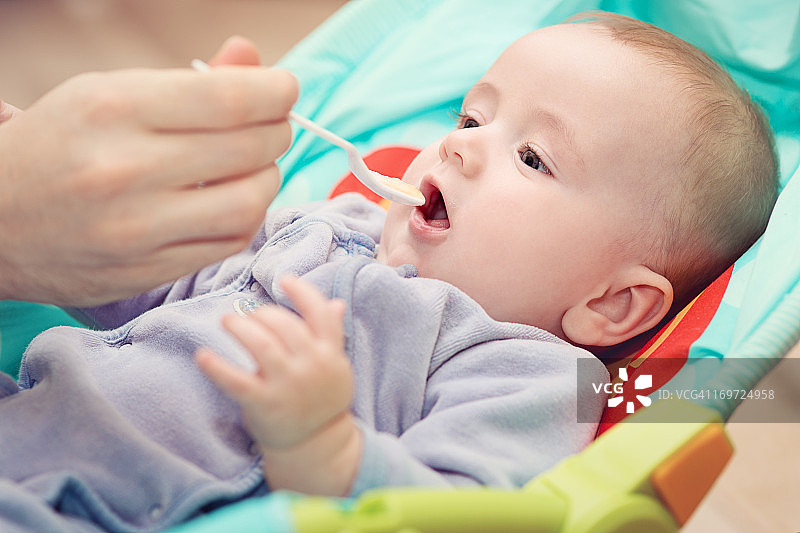 正在被喂食的六个月大婴儿图片素材