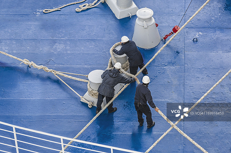 男人将缆绳固定在船上的系缆桩上图片素材