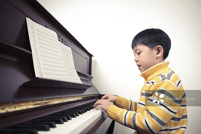 弹钢琴的小男孩图片素材
