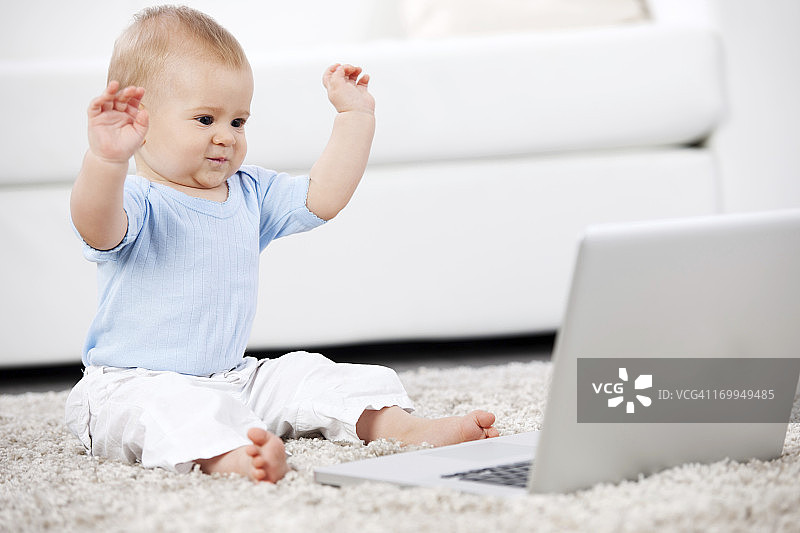 可爱的小男孩看着笔记本电脑图片素材