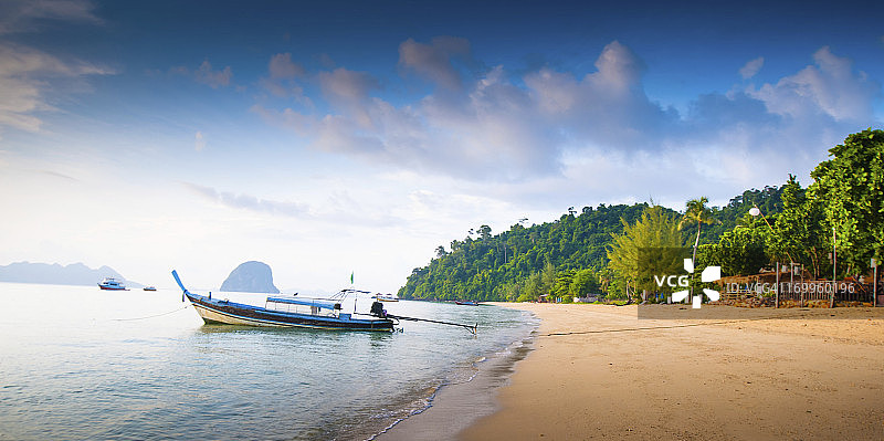 长尾船停靠在美丽的海滩上图片素材