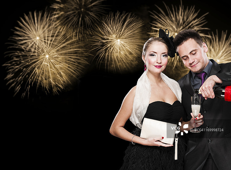 新年情侣在烟花夜空下手持香槟庆祝图片素材
