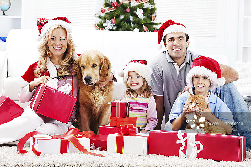 圣诞节期间与宠物一起享受的年轻家庭图片素材