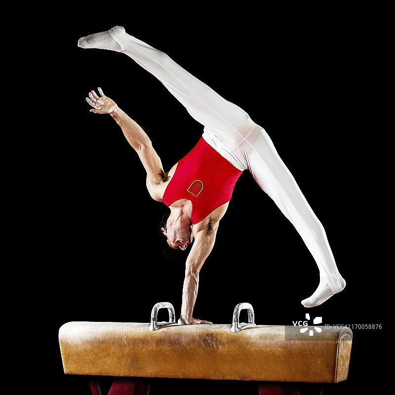 在鞍马上锻炼的年轻男运动员图片素材