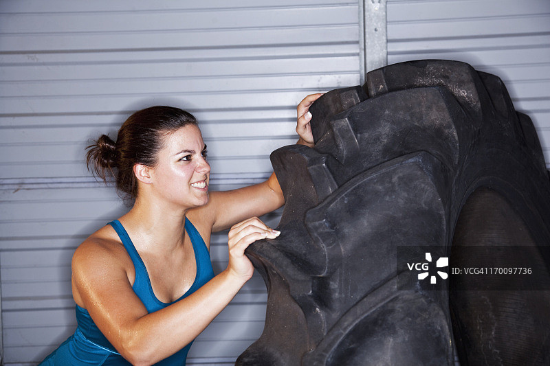 女人用拖拉机轮胎进行力量训练图片素材