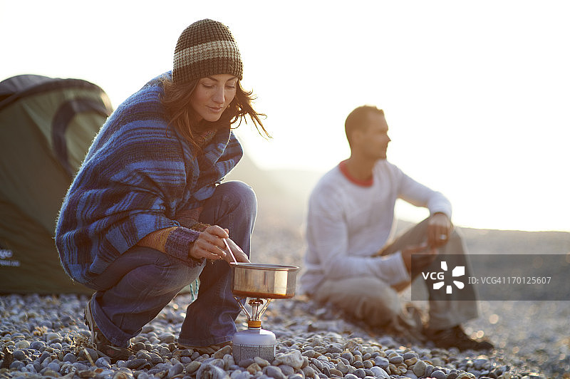在海滩帐篷外做饭的女人图片素材