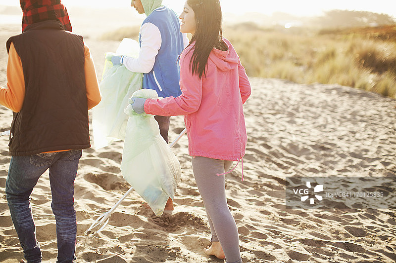 青少年在海滩上清理垃圾图片素材