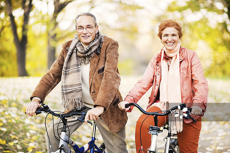 中年夫妇在公园里骑自行车图片素材