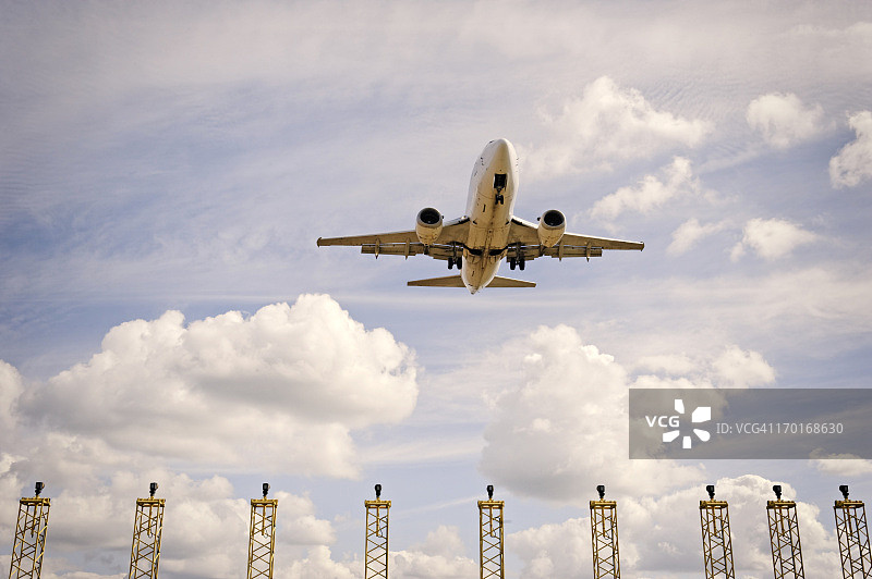 飞机在着陆灯的照射下接近跑道，位于比利时斯滕诺克泽尔的布鲁塞尔机场图片素材