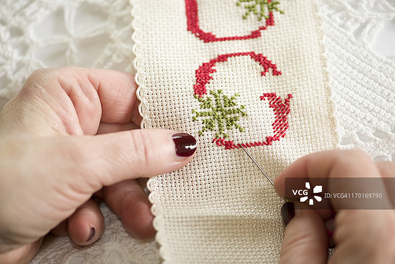 手持针线进行十字绣图片素材